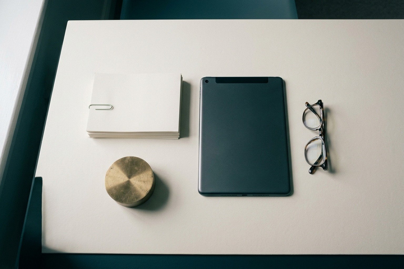 Corporate operational office desk with blueprint schematics, formal documents and clean slate accents